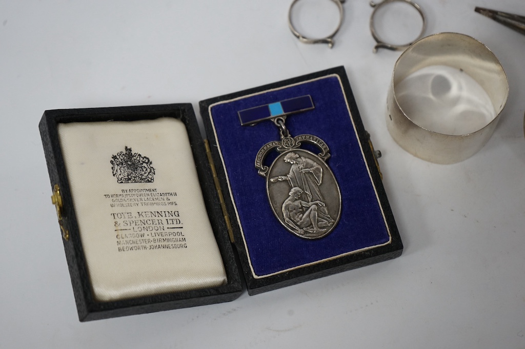 A pair of mid 18th century silver sugar nips, by Alexander Osborne, London, circa 1765, 11.6cm, together with a silver mounted glass match strike, a silver mounted inkwell, a silver napkin ring, a cased silver medallion